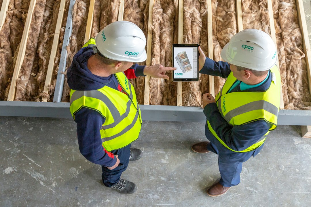 Construction engineers reviewing plans on tablet